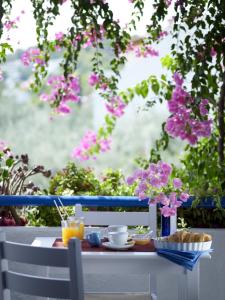 a table with food and drinks and flowers on it at Ninetta's Studios in Poros