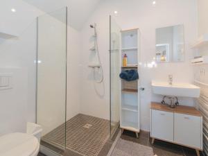 a bathroom with a shower and a toilet and a sink at Apartment Seaview Penthouse apartment by Interhome in De Haan