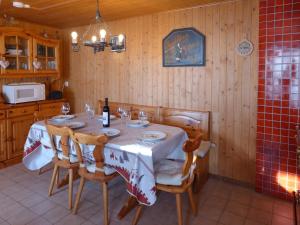 un comedor con una mesa con sillas y una botella de vino en Chalet Chalet Tsi-No by Interhome, en Gryon