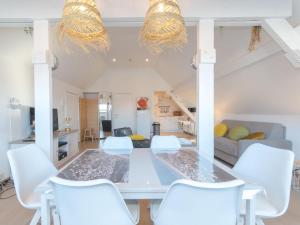 a dining room with a white table and white chairs at Apartment Seaview Penthouse apartment by Interhome in De Haan +8 photos