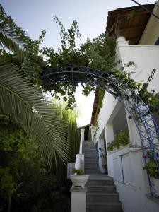 um arco que leva até uma casa com escadas em Ninetta's Studios em Poros
