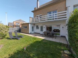 a house with a patio and chairs in the yard at Holiday Home Ruiterlaan with parking by Interhome in Bredene