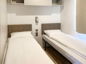 two beds in a hospital room next to each other at Holiday Home Bungalow Isola Premium by Interhome in Gudo +17 photos