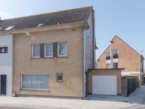 a brick house with a garage on a street at Holiday Home Ruiterlaan with parking by Interhome in Bredene +5 photos