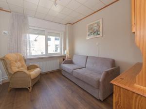 a living room with a couch and a chair at Holiday Home Ruiterlaan with parking by Interhome in Bredene