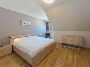 een slaapkamer met een bed en een dressoir bij Holiday Home Boonenhove 50 by Interhome in De Haan