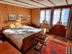 una camera con un grande letto in una stanza con pareti in legno di Apartment Hübeli - Kopp by Interhome a Zweisimmen