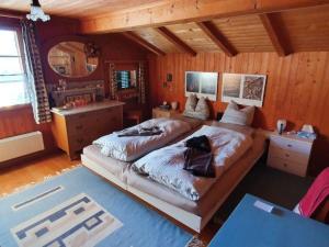 1 dormitorio con 2 camas en una habitación con paredes de madera en Apartment Hübeli - Kopp by Interhome en Zweisimmen