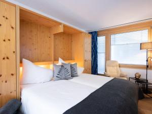 een slaapkamer met een groot wit bed en een raam bij Apartment Chesa Corvatsch 211 - Champfer by Interhome in Champfer