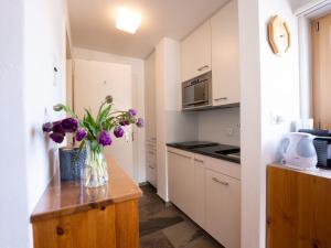 eine Küche mit einer Vase lila Blumen auf der Theke in der Unterkunft Apartment Chesa Corvatsch 211 - Champfer by Interhome in Champfer