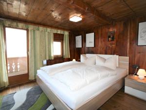 a large white bed in a room with wooden walls at Holiday Home Ferienhaus Lamplberg by Interhome in Hippach