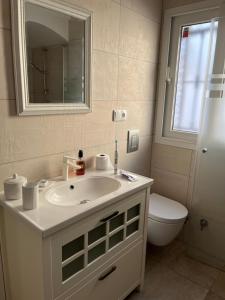 ein Badezimmer mit Waschbecken, Toilette und Spiegel in der Unterkunft Del Sol in Altea