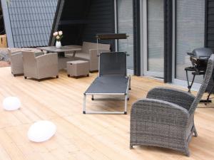 um pátio com 2 cadeiras, uma mesa e comodidades para churrascos em Holiday Home Ferienhaus Bude 92 by Interhome em Bad Arolsen