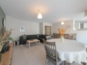a living room with a table and a couch at Apartment Westhinder with balcony by Interhome in Blankenberge