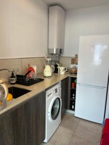 eine Küche mit einer Waschmaschine und einem weißen Kühlschrank in der Unterkunft Del Sol in Altea + 10 Fotos