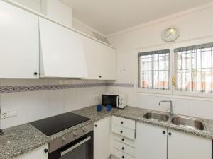 uma cozinha com armários brancos e um lavatório em Holiday Home Kocic by Interhome em L'Escala