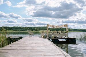 a pier with a wedding altar on a lake at Niezwykła Cisza Glamping & Sauna in Zelwa