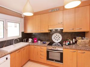 a kitchen with wooden cabinets and a sink at Holiday Home Florencia by Interhome in Pals