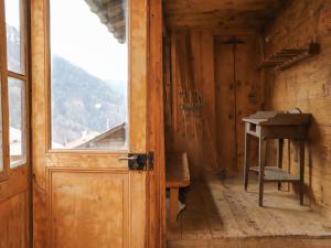 eine offene Tür in einem Holzzimmer mit Fenster in der Unterkunft Chalet Chalet Pierre Fleur by Interhome in Gryon