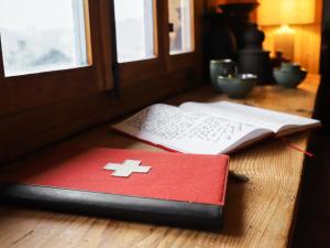 ein rotes Buch mit einem Kreuz neben einer Tastatur in der Unterkunft Chalet Chalet Pierre Fleur by Interhome in Gryon