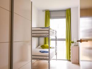 ein Schlafzimmer mit Etagenbetten und einem Fenster in der Unterkunft Apartment PUIG ROM by Interhome in Empuriabrava