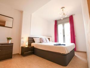 Schlafzimmer mit einem Bett mit roten Vorhängen und einem Fenster in der Unterkunft Apartment PUIG ROM by Interhome in Empuriabrava