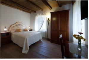 a bedroom with a bed and a table and a window at Affittacamere Valnascosta in Faedis