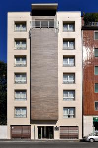un alto edificio bianco con un edificio di BB Hotels Aparthotel Bicocca a Milano