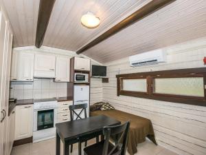 a small kitchen with a table and a dining room at Holiday Home Anttoora a-sauna by Interhome in Pori