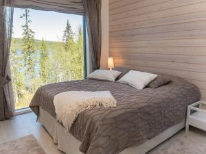 1 dormitorio con 1 cama y ventana grande en Holiday Home Holy lake rantasauna by Interhome en Niskala