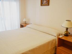 a bedroom with a bed and a lamp on a table at Apartment Deltamar by Interhome in Sant Carles de la Ràpita