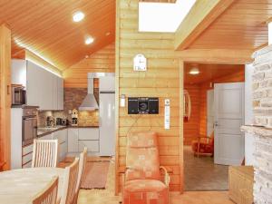 cocina con paredes de madera, mesa y sillas en Holiday Home Tahkolahti by Interhome, en Tahkovuori