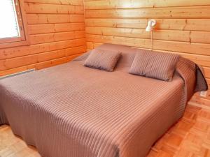 1 dormitorio con 1 cama en una habitación de madera en Holiday Home Tahkolahti by Interhome, en Tahkovuori