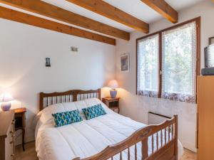 a bedroom with a large bed and two windows at Holiday Home Résidence Les Lauriers by Interhome in Meschers-sur-Gironde