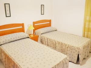 una habitación con dos camas y una lámpara en Apartment Aldea Park by Interhome, en Sant Carles de la Ràpita