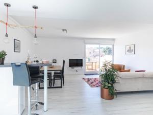 Una sala de estar blanca con un sofá y una mesa. en Apartment Les Roches Bleues-1 by Interhome, en Le Pradet