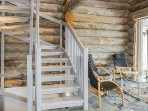 a staircase in a log house with chairs and a table at Holiday Home Villa toprakka b by Interhome in Sirkka