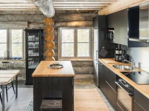 a kitchen with black cabinets and a wooden ceiling at Holiday Home Villa toprakka b by Interhome in Sirkka