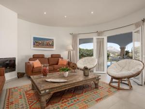 ein Wohnzimmer mit einer Couch und einem Tisch und Stühlen in der Unterkunft Villa Villa Bonheur by Interhome in Jávea