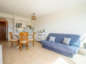 ein Wohnzimmer mit einem blauen Sofa und einem Tisch in der Unterkunft Apartment Les Embruns-16 by Interhome in Saint-Cyprien