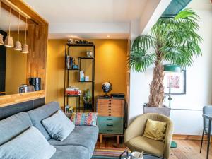 a living room with a couch and a palm tree at Apartment Zirlinga-9 by Interhome in Bidart