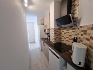 a kitchen with a counter with a tv on the wall at Apartamentos en Denia frente al Puerto! in Denia