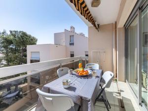 a balcony with a table with a bowl of fruit on it at Apartment Le Grand Large-1 by Interhome in Hyères
