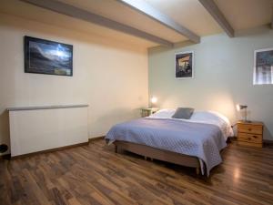 een slaapkamer met een bed en een houten vloer bij Holiday Home Ty Coz by Interhome in Pleurtuit