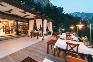 a restaurant with tables and chairs on a patio at Lissiya Hotel in Faralya