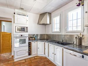 a kitchen with white cabinets and white appliances at Holiday Home La campagne du Colorado by Interhome in Rustrel