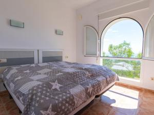 a bedroom with a bed and a large window at Apartment Azul Celeste by Interhome in Benitachell