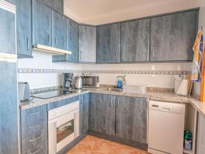 a kitchen with blue cabinets and white appliances at Apartment Azul Celeste by Interhome in Benitachell