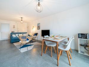 a dining room and living room with a table and chairs at Apartment Résidence Coté Baie by Interhome in Saint-Pierre-Quiberon