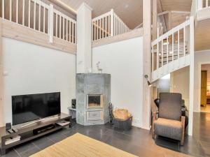 Una sala de estar con televisión y chimenea. en Holiday Home Villa utu by Interhome, en Kolinkylä
